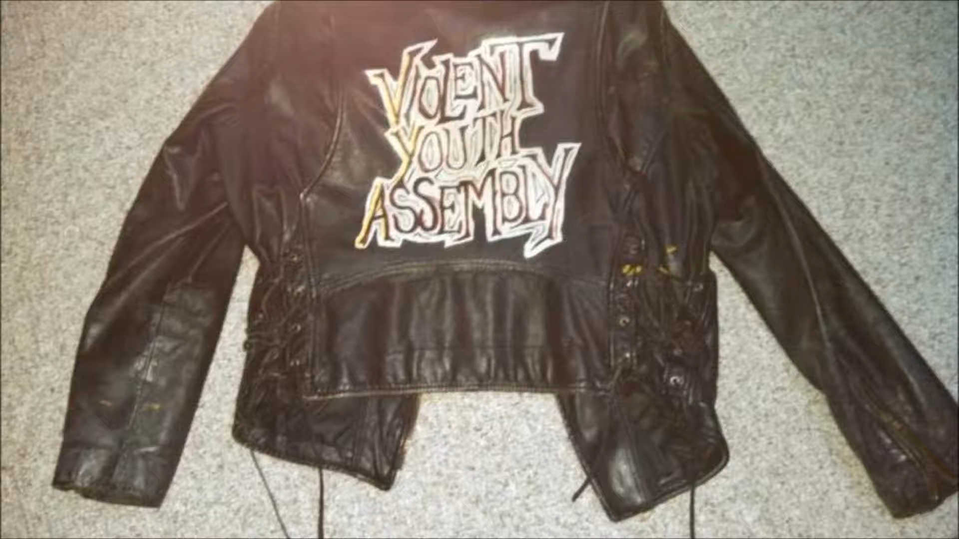Leather jacket with black and whit band logo painted on back